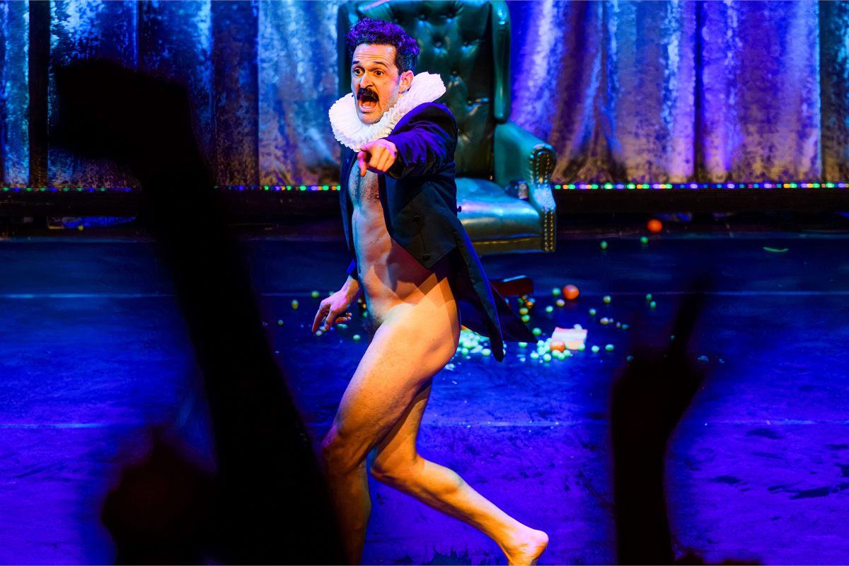 Damien Warren-Smith as Garry Starr dashing across the stage under blue light in Garry Starr: Classic Penguins