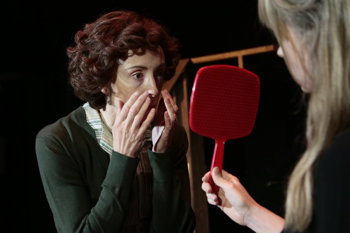 Two of the women in The Revlon Girl at Park Theatre, one holding up a red hand mirror