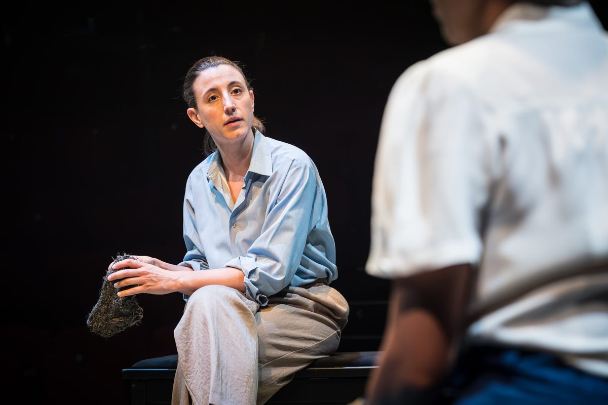 A member of the all-female company in a small and quiet light. Photo by Marc Brenner