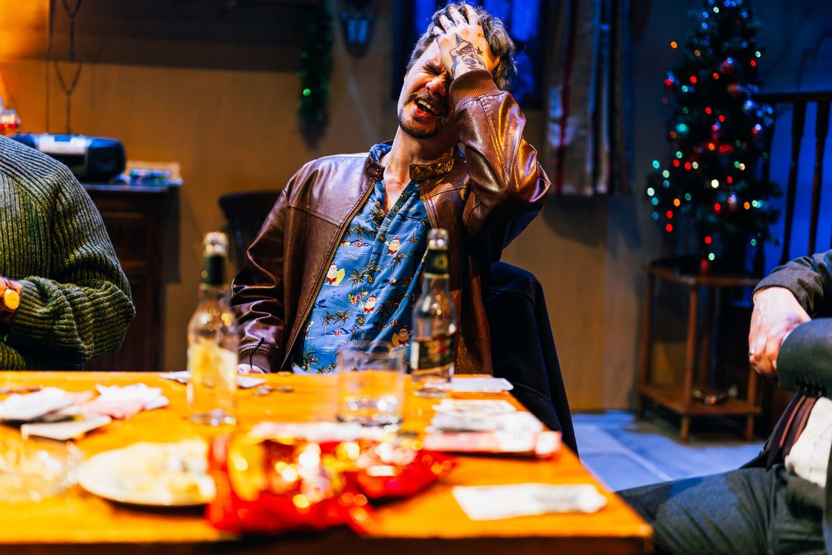 A drunken card player slumped at the table on Christmas Eve in The Seafarer at Greenwich Theatre