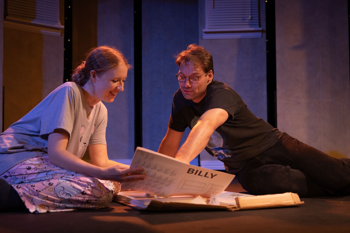 Miranda Colmans and Cyril Blake with flat-pack furniture instructions in We’ll Always Have Paris